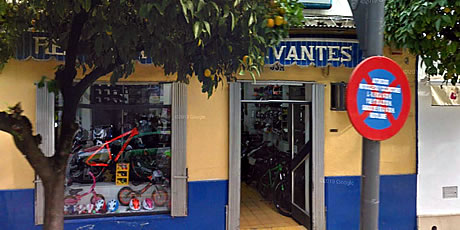vista de la tienda moto cervantes detras del arbol de narajas